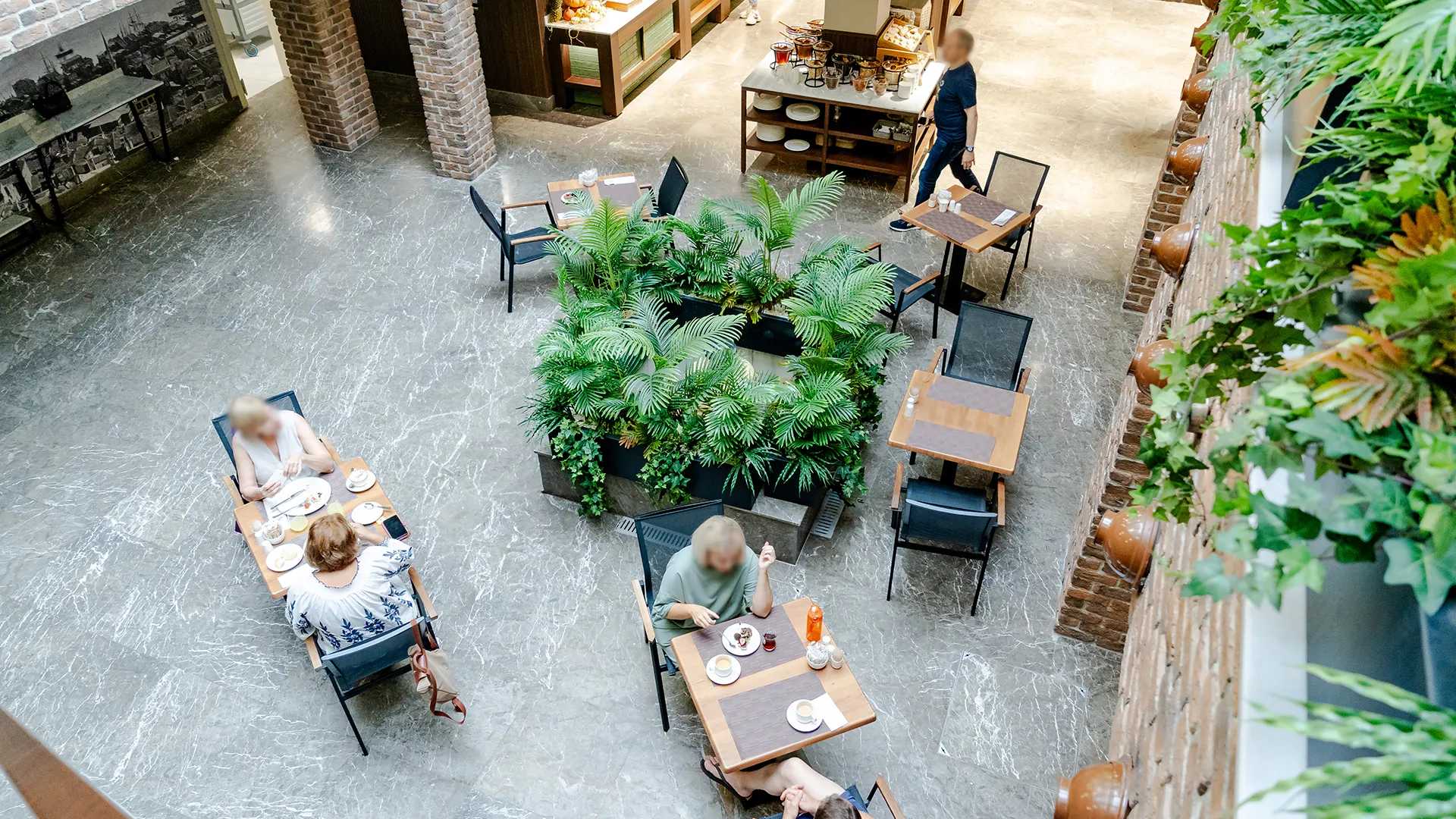 An aerial view of people eating at tables in a hotel restaurant.