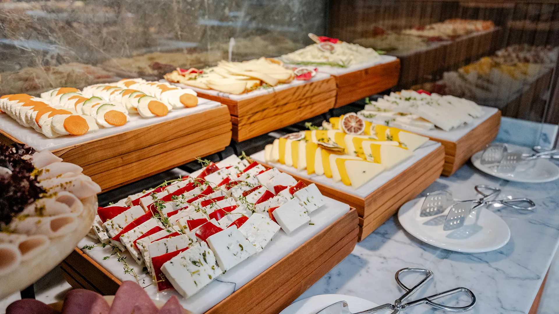 A cheese buffet with a variety of different types of food.